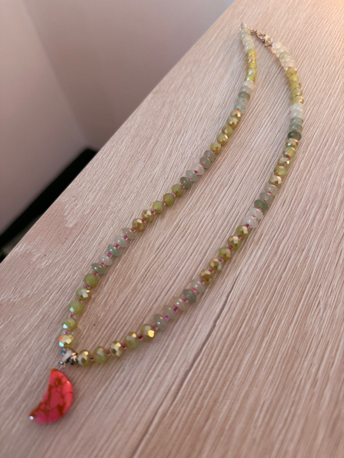 Collar de cristales verdes con colgante luna en rojo